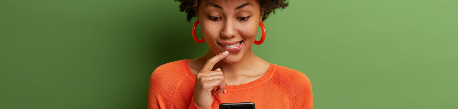 Une jeune femme sur son smartphone, hésitant à ouvrir un message relatif à une mise à jour Chrome.