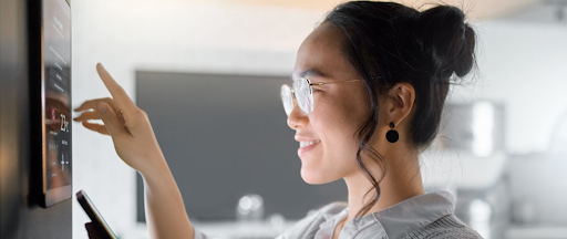 Une femme utilisant un objet connecté à la maison