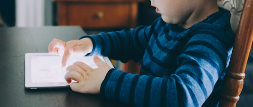 Un jeune enfant en train d’utiliser une tablette