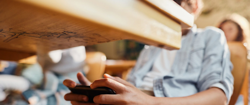 Un jeune garçon en train de se connecter aux réseaux sociaux pendant les cours