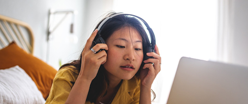 Une jeune femme portant des casques en train d’écouter de la musique