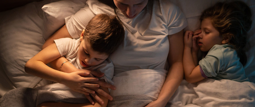 Une mère dormant avec ses enfants, loin des écrans