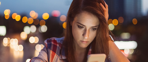 Une femme reçoit un appel suspect sur son smartphone, symbolisant les dangers du démarchage téléphonique.