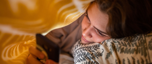 Une jeune femme connectée aux réseaux sociaux sur son smartphone