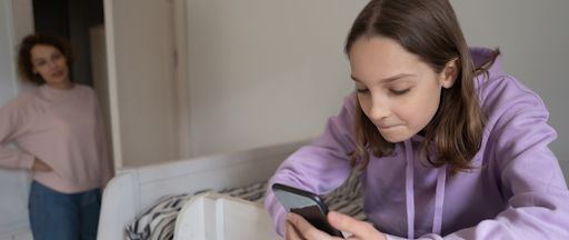 Parent surveillant l’utilisation des réseaux sociaux par un enfant.