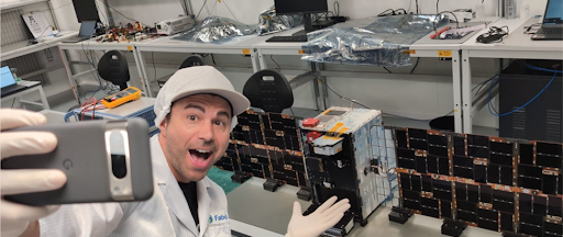 Mark Rober prend un selfie devant son projet SAT GUS