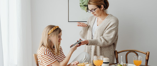 Une mère contrôle le smartphone de sa fille.