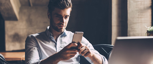 Une personne détendue regardant des vidéos sur un smartphone dans un espace convivial.